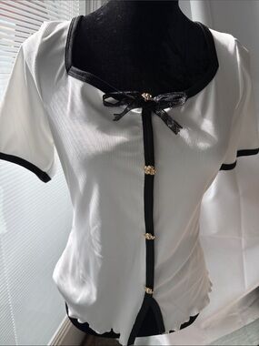 White Short-Sleeve Knit Top with Black Trim and Gold Accents